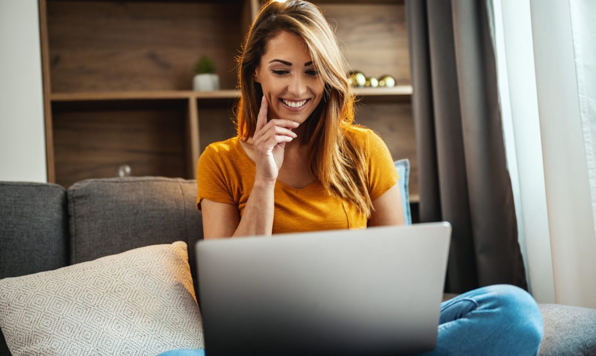 woman looking over her laptop smiling at her website