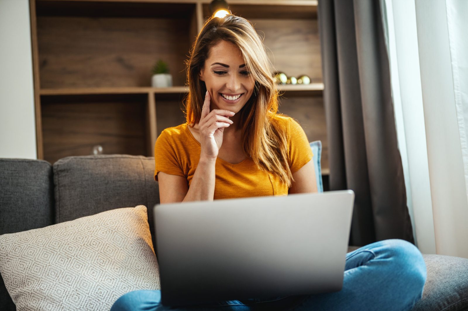 woman looking over her laptop smiling at her website
