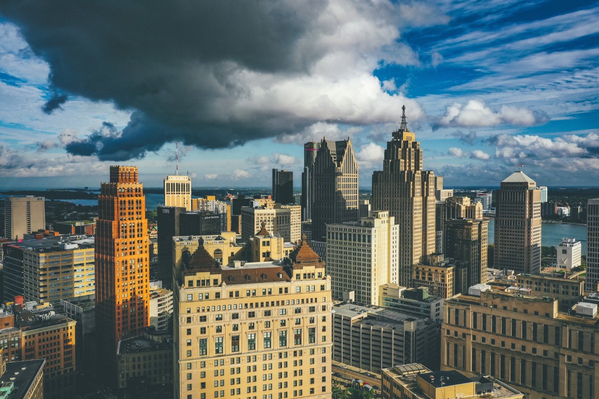 A cityscape of Detroit under the sunlight and a dark cloudy sky at daytime in Michigan in the US